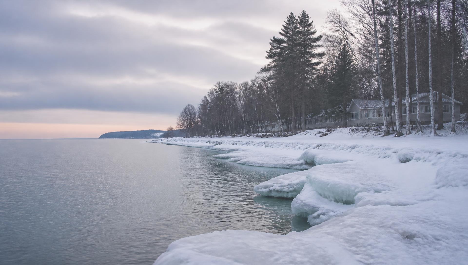 Ice along the snowy shoreline of Little Traverse Bay at dawn